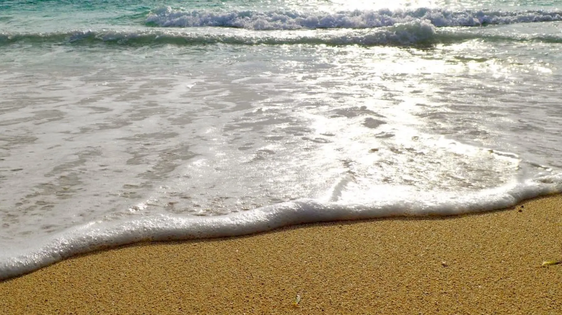 Vague translucide sur le sable blanc de Pinang